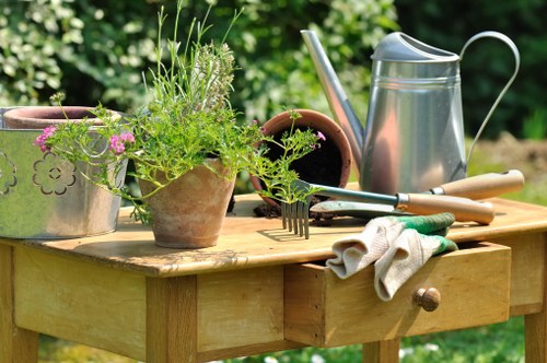 Back garden landscaping in Norwood Green with planting, lawn, and seating area